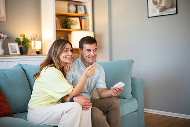 istock Couple relaxing on sofa at home watching tv 2244589673