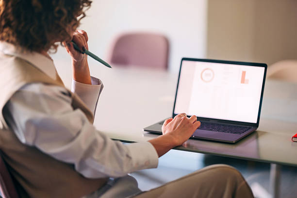 istock Focused Professional Analyzing Data On Laptop During Work Meeting With Pen In Hand 2244595031