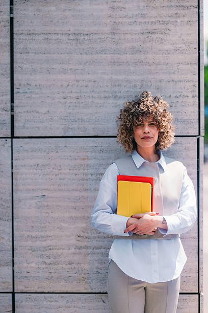 istock Professional Woman With Bright Notebooks Standing Against Modern Stone Wall 2244595099