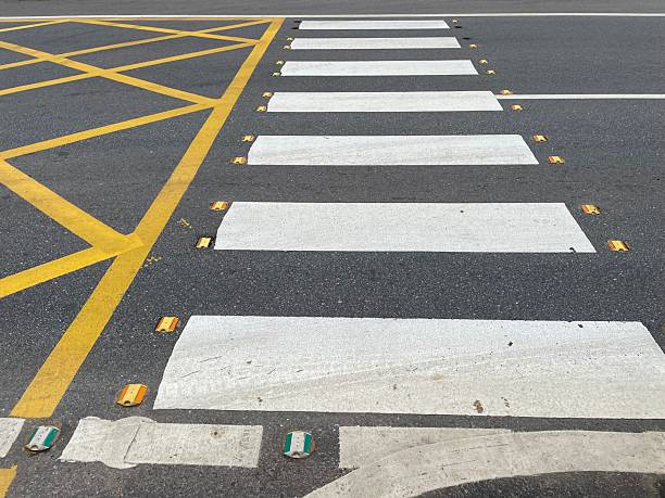 istock Pedestrian Crosswalk and Yellow Grid Road Markings on Asphalt 2244600531