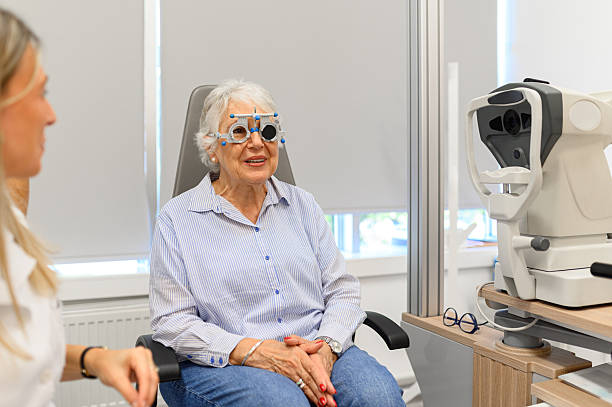 istock Female ophthalmologist observing senior woman's eyes while she undergoes vision test with phoropter at clinic 2244601229