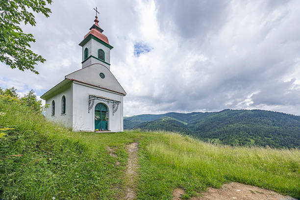 Chapel on a hilltop offering panoramic views of the forest mountains and sky