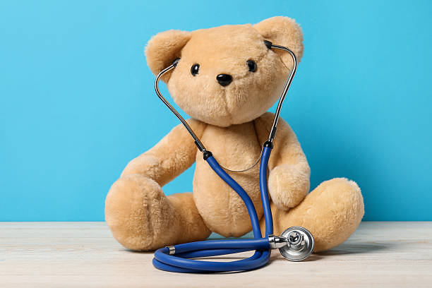 istock Pediatrics concept. Teddy bear with stethoscope on wooden table against light blue background 2244604290