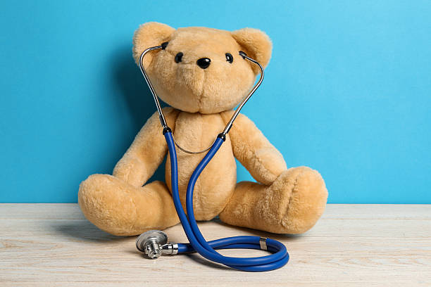 istock Pediatrics concept. Teddy bear with stethoscope on wooden table against light blue background 2244605083