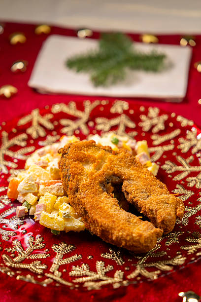 Fried carp serving with potato mayonnaise salad for Christmas Eve dinner