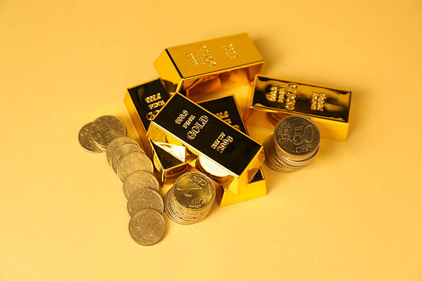 istock Gold bars and coins on golden background, above view 2244606845