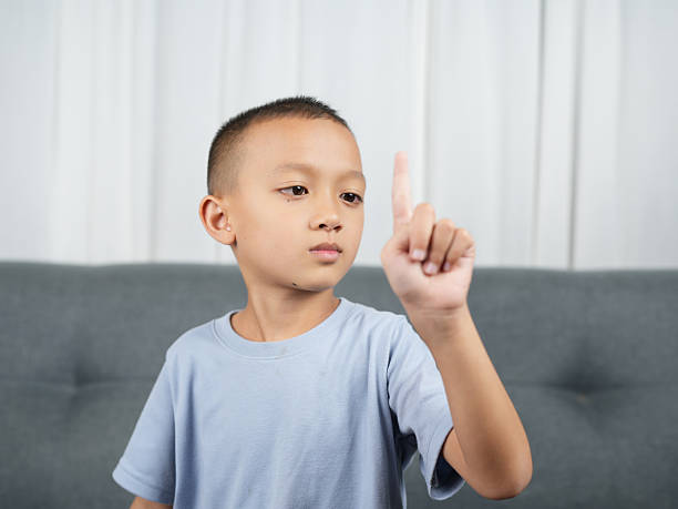 Angry preschool student doing stop sign in classroom.