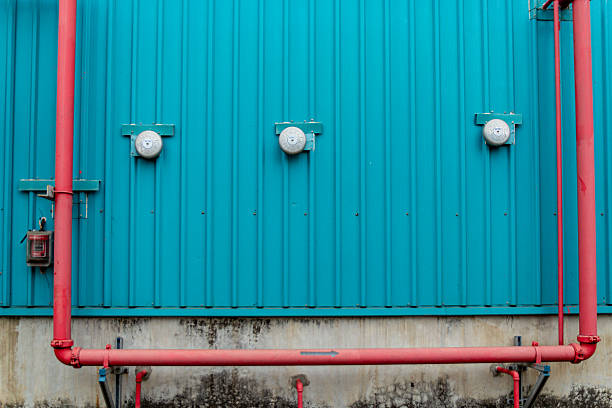 istock Turquoise wall shows three alarms and red pipes, creating contrast and visual interest. 2244610166