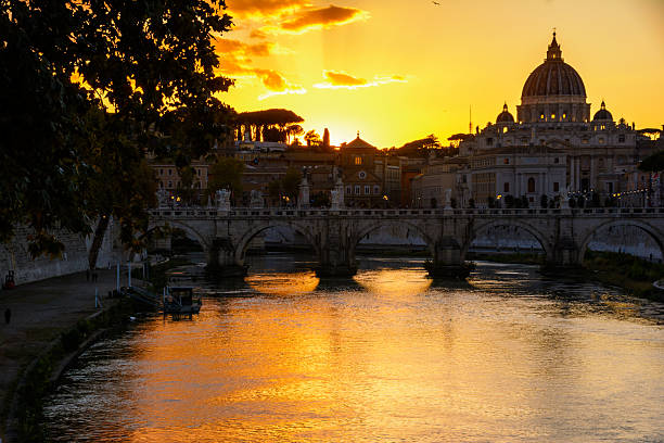 Rome, Italy - October 5, 2025: View of the Sant'Angelo bridge and St. Peter's dome at sunset.