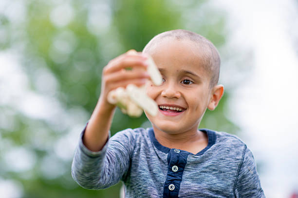 istock Happy Young Boy Plays Outdoors With Toy in Bright Daylight, Smiling and Laughing 2244614794