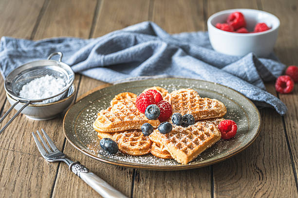 istock Homemade waffles with powdered sugar and berries on a wooden table 2244614833