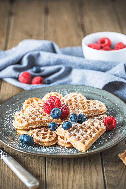 istock Homemade waffles with powdered sugar and berries on a wooden table 2244614835