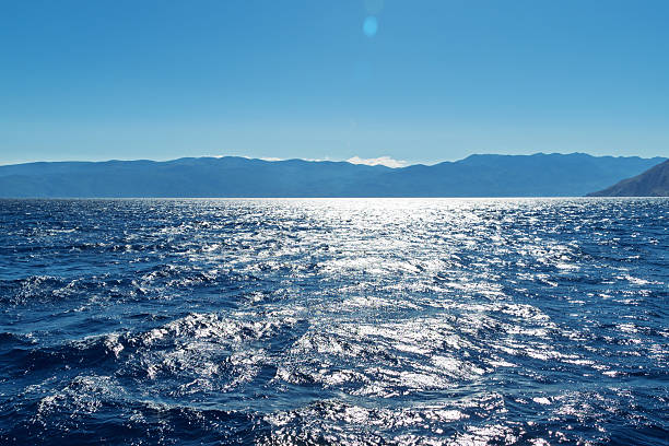 istock Sparkling waves on a sunny seascape with distant mountains 2244616297