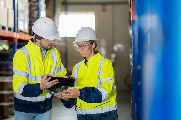 istock Two warehouse workers in safety gear check inventory levels and plan FIFO storage through a digital tablet in a large distribution warehouse. The image represents teamwork, technology, and efficient logistics management in the supply chain. 2244621124
