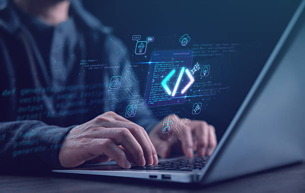 Software developer typing code on laptop with glowing AI and programming symbols, representing coding, software engineering, artificial intelligence, and innovation in digital technology. stock photo