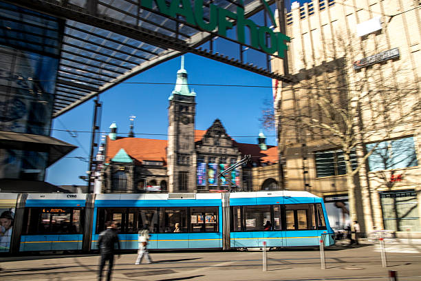 Chemnitz, Germany - March, 7, 2025: A city tram passing by the main tram station  near the St. Jacobs church and the shopping mall.  Motion blur.