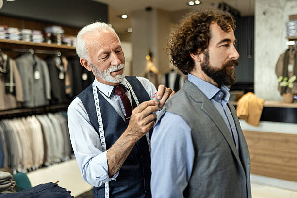 istock Mature Tailor Taking Measurements of Male Client in Workshop 2244630564