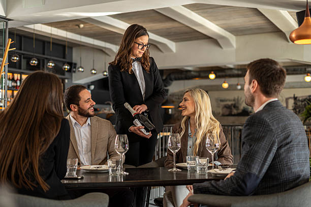 istock Waitress serving champagne to friends during dinner celebration 2244632136