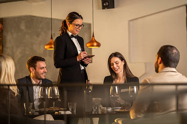 istock Waitress taking dinner order from smiling customers in restaurant 2244633043