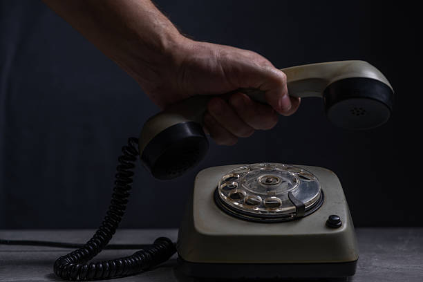Retro telephone on black background. Man hand holds handset