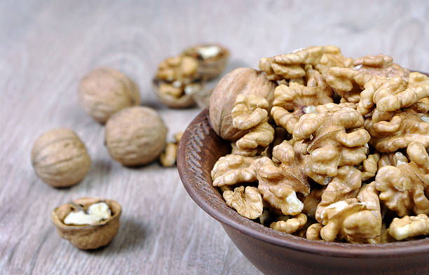 istock walnuts in a bowl on a wooden table. peeled walnuts close up. 2244635174