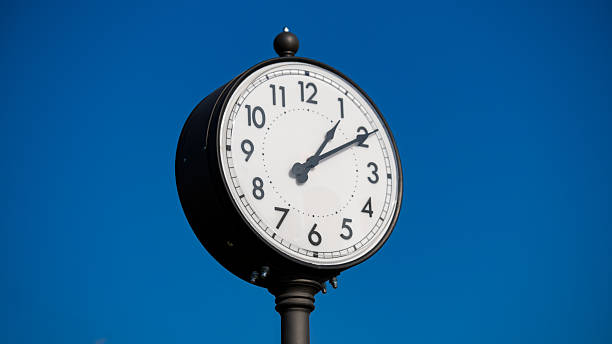 istock Vintage street clock against clear blue sky 2244636562