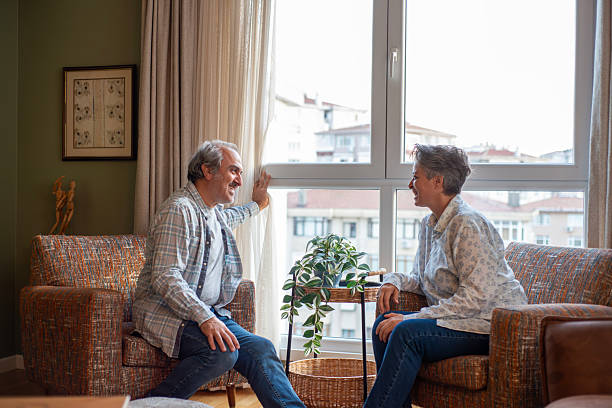 istock Mature woman talking to her husband while relaxing together on a sofa at home 2244637391