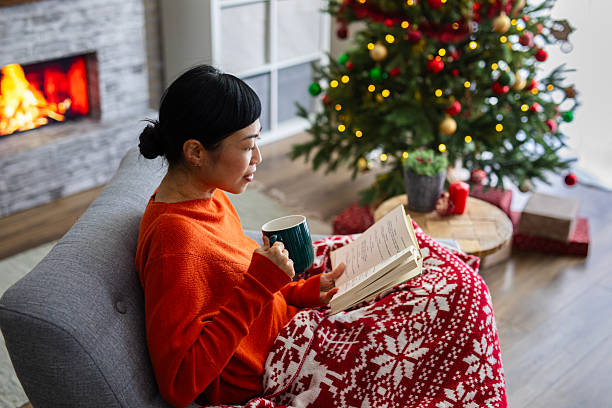 istock Woman spending a peaceful holiday evening reading by the fireplace 2244637889