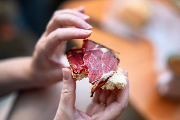 istock A bitten sandwich with bread and cured red meat in female hands during breakfast, ideal for food blogs and lifestyle content 2244637926