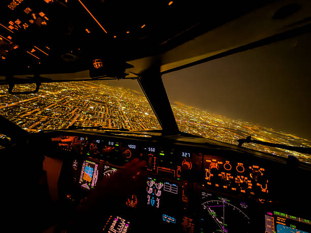 A mesmerizing view from inside a modern airliner cockpit glowing with amber and green lights, overlooking a vast city illuminated below.