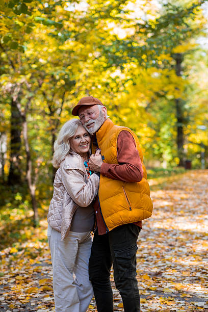 istock Elderly man and woman embracing while walking in park 2244640051