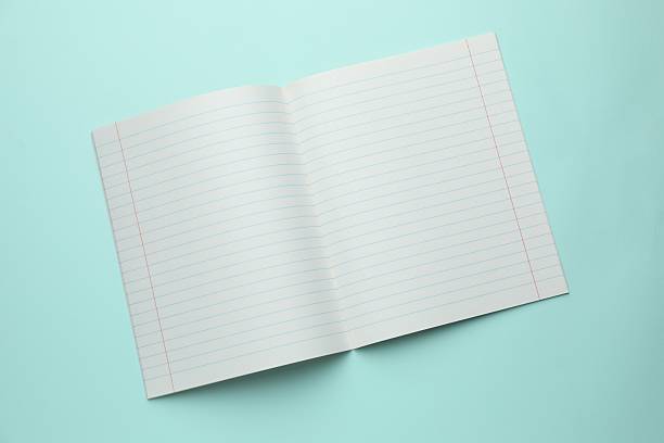 Open copybook on light blue background, top view. School stationery