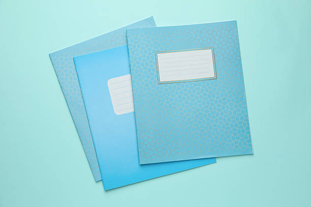 Colorful copybooks on light blue background, flat lay. School stationery