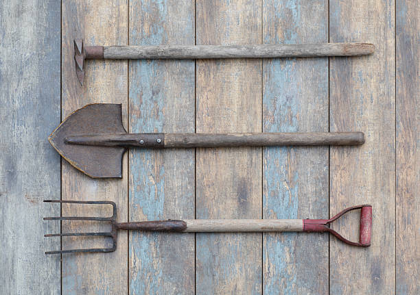 old garden fork standing against a wooden slatted fence