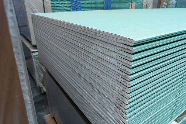 istock Green drywall sheets stacked neatly in a warehouse ready for construction projects during daylight hours in an urban setting 2244645839