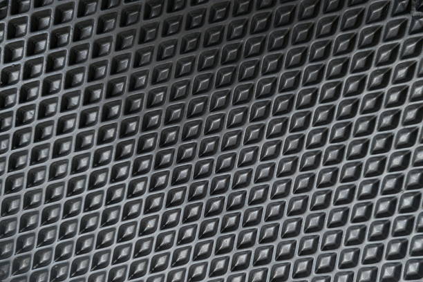Close-up view of a black material featuring a diamond pattern texture. The geometric shapes create a striking visual appeal, commonly found in various industrial or decorative applications.