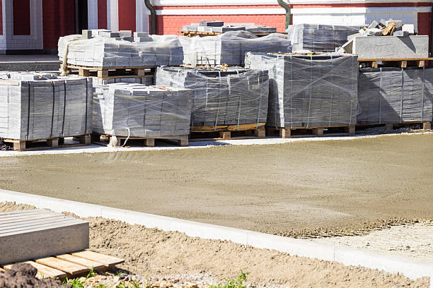 istock Concrete bricks for paving the sidewalk, packed in blocks on pallets, stand at a construction site 2244646505
