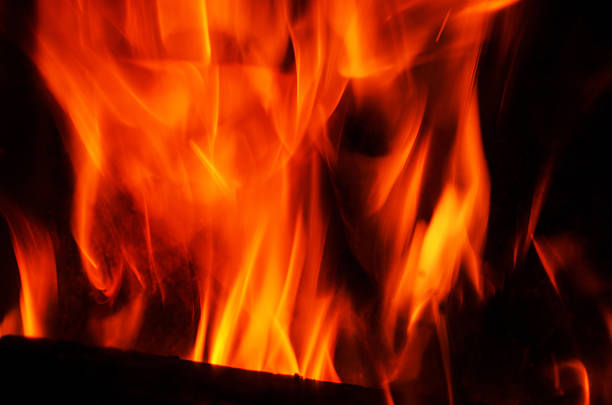 The bright orange and yellow flames create a mesmerizing effect against the dark background, evoking warmth and energy