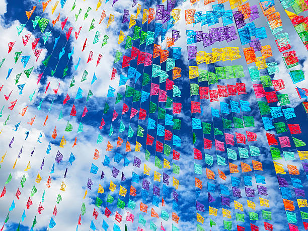 istock Vibrant Mexican papel picado fluttering against a cloudy blue sky. 2244652385