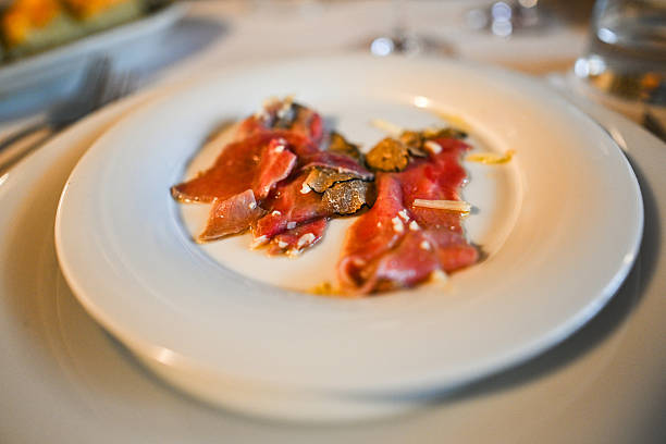 Food appetizer concept Sliced Dried Cured beefs Bresaola on black slate stone board