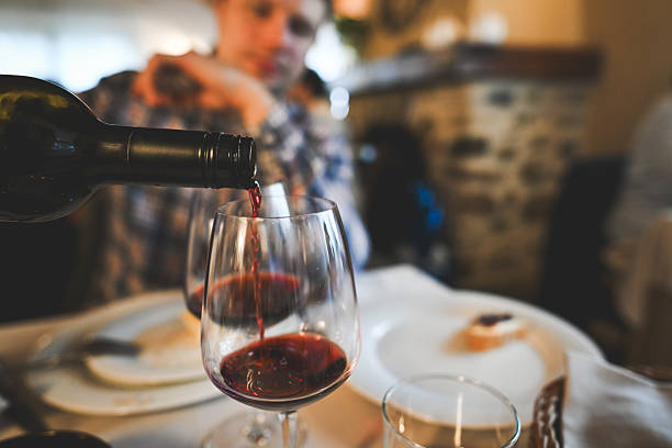 istock Pouring red wine into wine glasses at restaurant dinner 2244654859