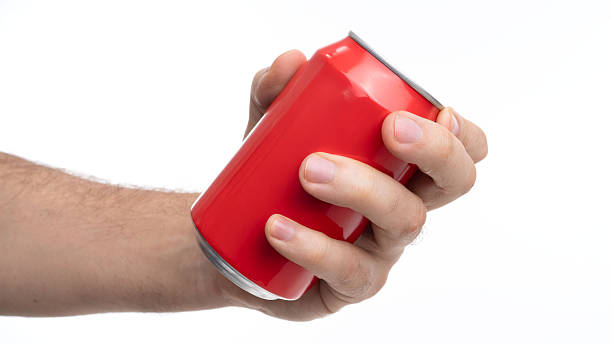 istock Hand holding a red beverage can in a neutral background during a casual moment 2244659900