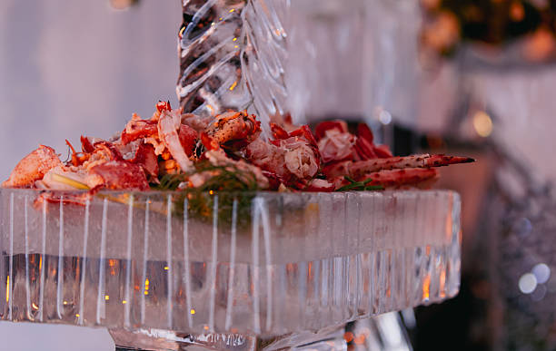 A close-up of a seafood platter featuring lobster tails and shellfish arranged on a frosted ice display. Warm lighting highlights colors and textures, suitable for menus, dining or culinary promotions.