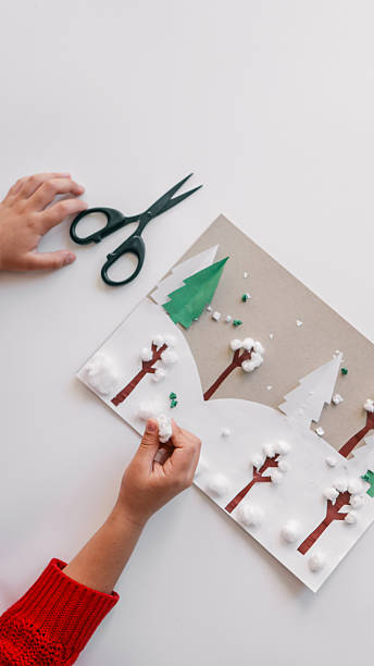 istock Child's winter art project with scissors and paper on a white background 2244662006