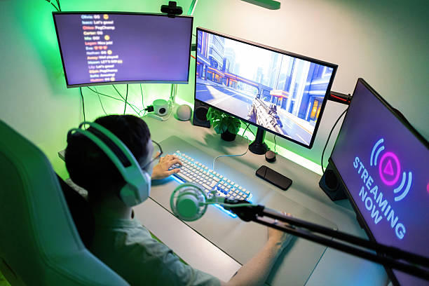 istock Young man gaming, live streaming, engaging his audience on an online platform on multiple computer screens 2244662366