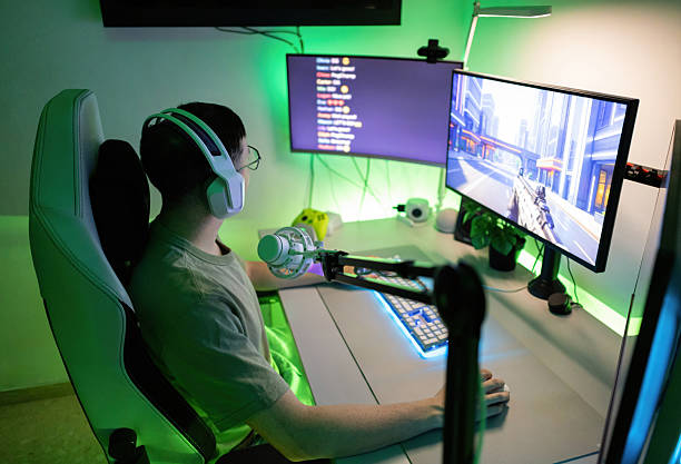 istock Young man playing and live streaming video game sitting in gaming chair with headset and microphone in home setup 2244662421