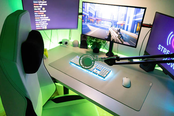 istock Gamer workstation with desktop computer, monitors, keyboard, microphone, and chair for streaming video game content online 2244662573