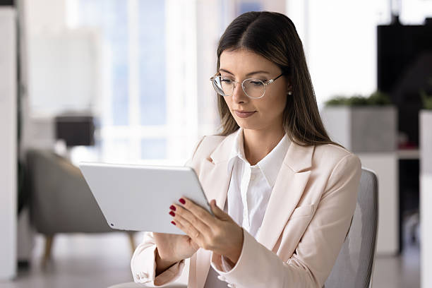 istock Focused Latin CEO woman in glasses typing on digital tablet 2244666428