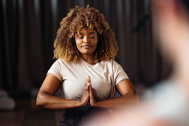 Woman Meditates In Quiet Yoga Class Studio With Hands In Prayer Pose