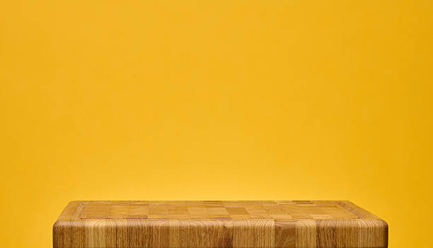 istock A wooden cutting board made from end grain on a bright yellow background 2244669062